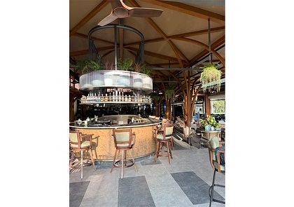 The central bar at the Karnataka Golf Association, with integrated overhead planters. This design brings greenery into the heart of the social space, softening the architectural structure and adding a touch of living art.