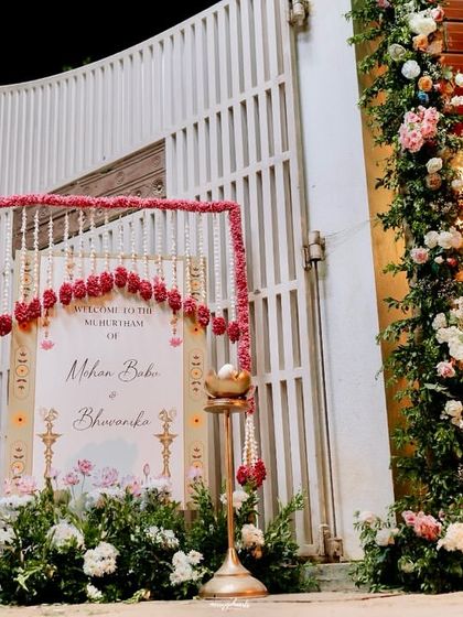 A grand entrance for a Muhurtham, with a custom welcome sign framed by florals and traditional decor elements.