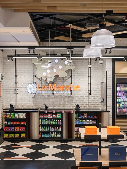 A view of the Le Marche checkout area, where the brand's story is reinforced through visual cues. The clean, modern design with industrial-style lighting and slatted wood details communicates quality, curation, and ease.