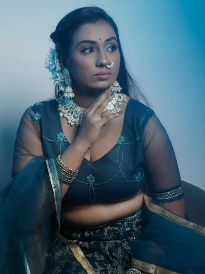 A full-length view of the model, showcasing the elegant blue lehenga and the complementary makeup.