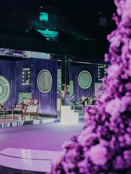 A glimpse of the psychedelic Sangeet decor, with a focus on the custom stage and lounge area. The hypnotic patterns and purple lighting created a truly immersive and otherworldly experience.