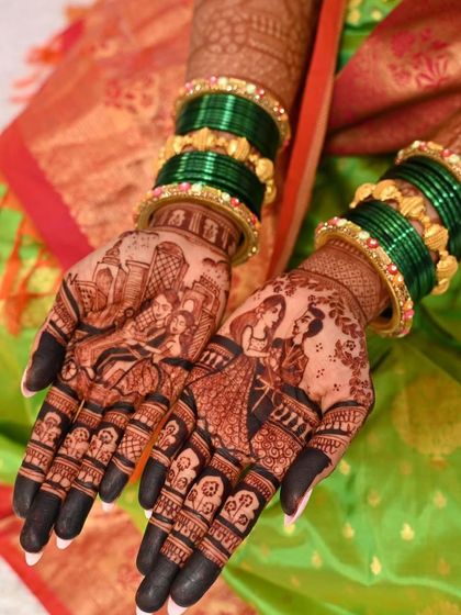 A beautiful shot of a bride's hands, adorned with custom family portraits. The rich green bangles complement the dark henna stain, creating a picture-perfect look.