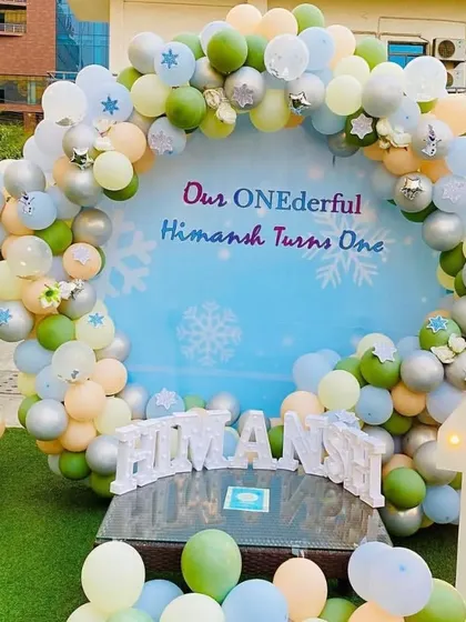 I can transform any outdoor space for a beautiful celebration, like this "ONEderful" first birthday party. This setup features a large themed backdrop, a custom balloon arch in pastel colors, and light-up marquee numbers that look great day or night.