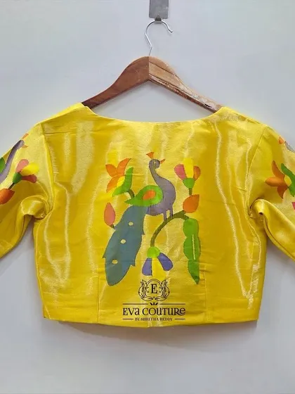 The back of the yellow Paithani blouse, featuring a large, colorful woven peacock motif. This is a statement piece that can be paired with any saree or lehenga.
