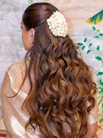A simple and elegant half-updo with a cluster of white flowers. This is a timeless look for any pre-wedding event, like this Mandap Murat ceremony.