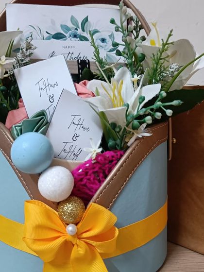 Another angle of the blue and yellow birthday basket, highlighting the beautiful floral arrangement and thoughtful curation.