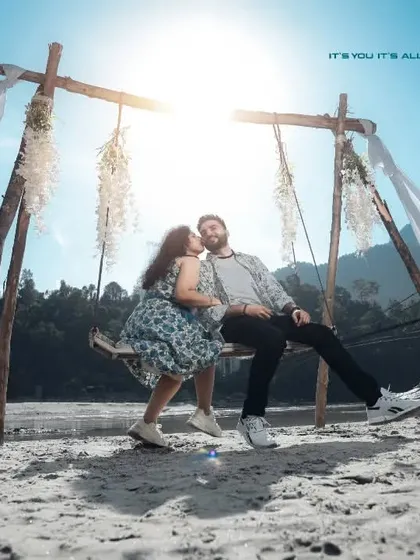 A beautiful shot of the couple on a swing set up on the banks of the Ganga. The backlighting from the sun creates a dreamy, romantic glow.