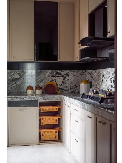 The kitchen features a mix of open and closed storage, with pull-out wicker baskets adding a touch of rustic charm.