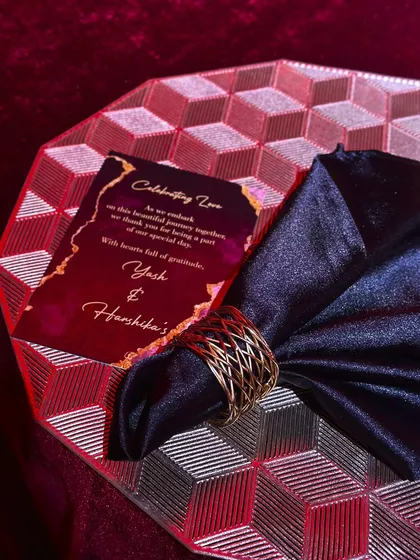 Design is in the details. For this dramatic red-themed Sangeet, every element of the tablescape, from the geometric charger plates to the custom menu cards and gold napkin rings, was intentionally chosen to tell a story of luxury.