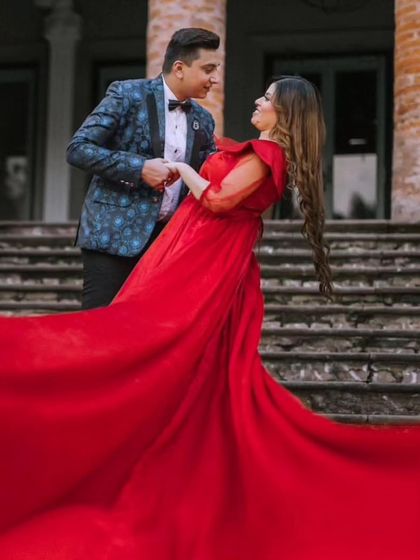 A beautiful candid moment of a couple dancing. The red gown with its detachable sleeves and long trail adds a grand, fairytale quality to this architectural pre-wedding location.