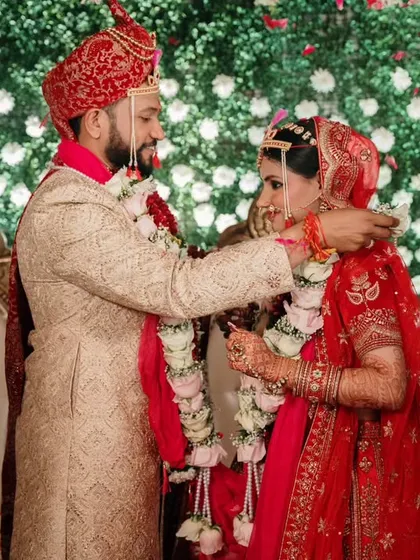 The Varmala ceremony, a symbol of mutual acceptance. We capture this pivotal moment against a stunning floral backdrop, highlighting the couple's first ritual as partners.