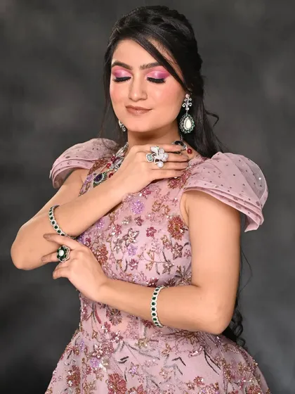 A full shot of the pink cut-crease makeup paired with an elegant lavender gown. The bold eye makeup is balanced by a soft hairstyle, creating a cohesive and striking look for a fashion editorial.