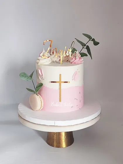 A simple and elegant Baptism cake for little Zinaida. The pink and white ombre design is accented with a gold cross, macarons, and eucalyptus leaves.