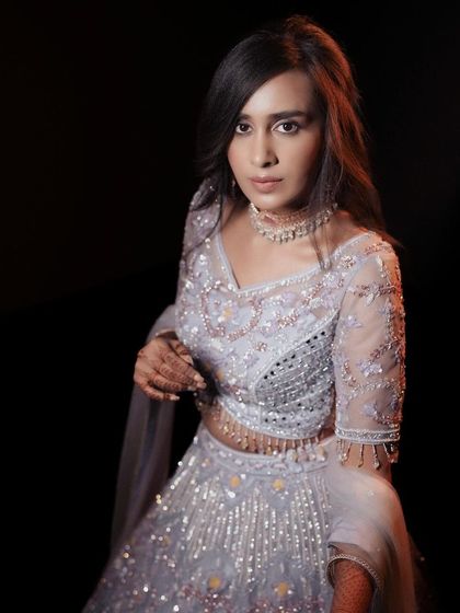 A beautiful portrait of the bride in her light blue lehenga, with a dark background making her stand out.