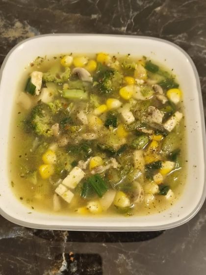This is a perfect example of a hearty, vegetarian soup packed with nutrients. It's filled with broccoli, corn, mushrooms, and tofu, making it a complete and satisfying meal. Eating a plant-based diet can be a delicious and vibrant lifestyle.