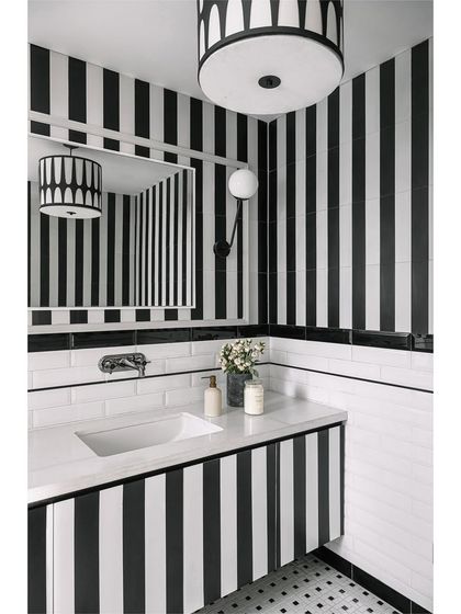 The media lounge powder room is a captivating blend of personality and style. We used bold black and white stripes to create a dramatic yet cozy space, proving that bathrooms can tell a story.