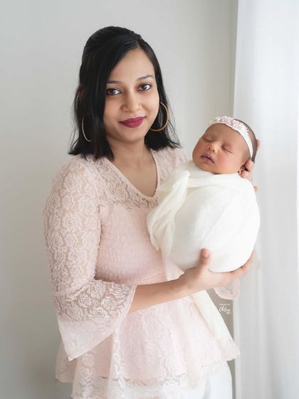 A mother's gentle hold. This portrait showcases the serene bond between mother and newborn, framed with soft, natural lighting for a dreamy and classic look.