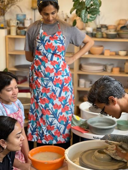 A group of students gathers around the wheel for a demonstration, their focused expressions showing their eagerness to learn.