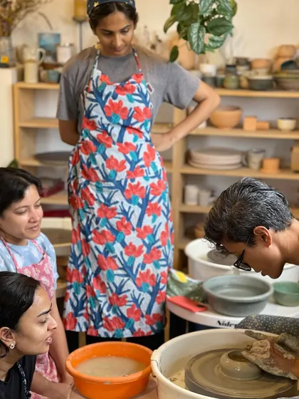 A group of students gathers around the wheel for a demonstration, their focused expressions showing their eagerness to learn.