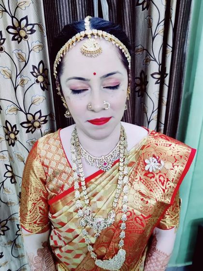 A close-up of Jaylakshmi's Varapooja makeup, featuring soft pink eyeshadow and a classic red lip, a beautiful choice for mature skin.