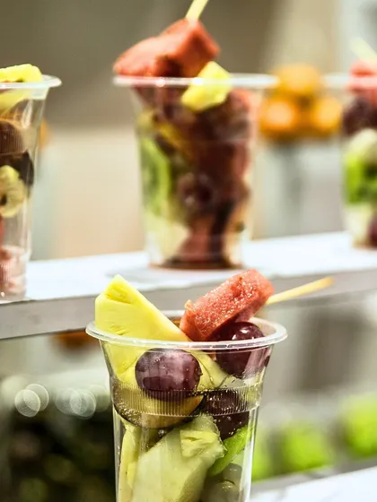 Mixed fruit cups with pineapple, watermelon, and grapes. A colourful and refreshing treat that's easy for guests to enjoy while mingling.