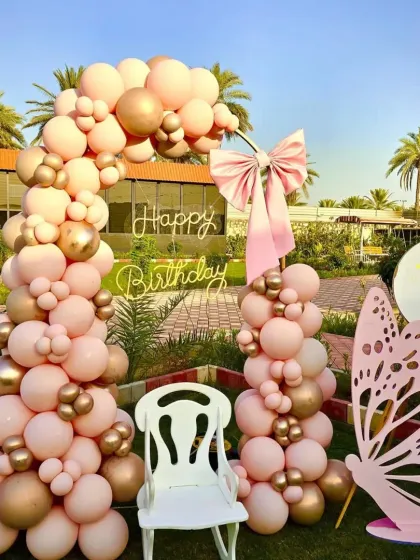 We specialize in creating elegant and dreamy outdoor celebrations. This butterfly-themed first birthday features a beautiful pastel pink and gold balloon arch, a custom neon sign, and a giant butterfly prop for the perfect photo op.