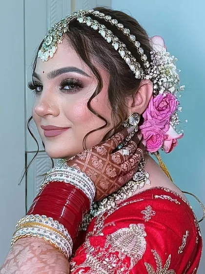 A beautiful shot of the bride looking over her shoulder. The soft curls framing her face and the floral details in her hair add a romantic touch to the overall look.