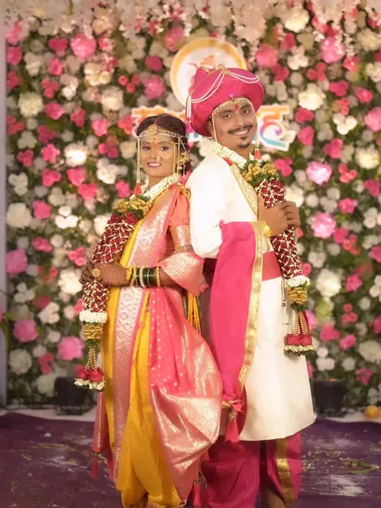 A classic back-to-back pose of the bride and groom in their traditional Maharashtrian wedding attire.