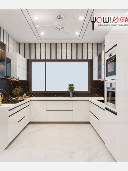 A full view of the U-shaped black and white kitchen, showcasing the ample counter space, large window for natural light, and striped wallpaper that adds a unique graphic element.