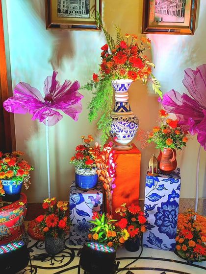 A decor corner filled with Turkish and Indian elements. I used patterned pedestals, ceramic vases with marigolds, and large, artistic flowers to create a vibrant and culturally rich photo spot.