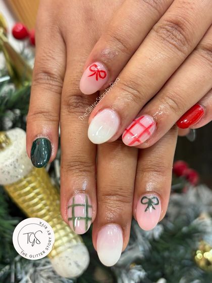 A very festive Christmas manicure! This set features a mix of hand-painted plaid, tiny bows, and classic red and green colors for a cheerful holiday look.