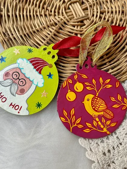 A cute Santa Claus and a partridge-in-a-pear-tree themed wooden Christmas ornament.