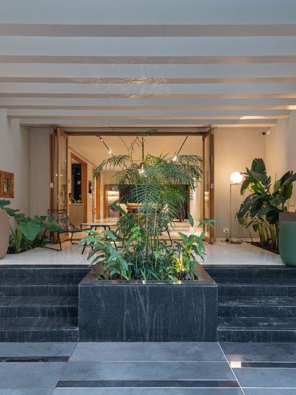 The entryway at night, where strategic up-lighting on the steps and planters creates a warm and dramatic welcome. This demonstrates how lighting design is integral to our architectural vision.