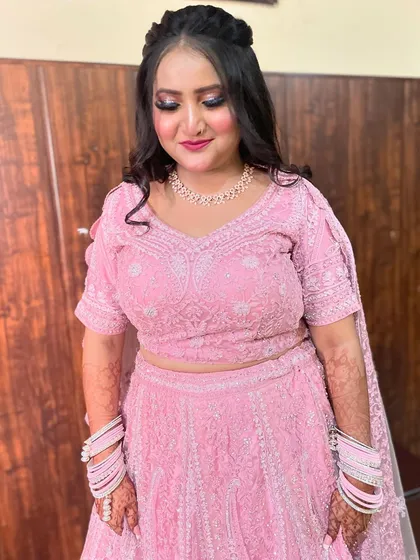 A lovely engagement bride in a full pink chikankari lehenga. The makeup is soft and romantic, with a focus on the eyes.