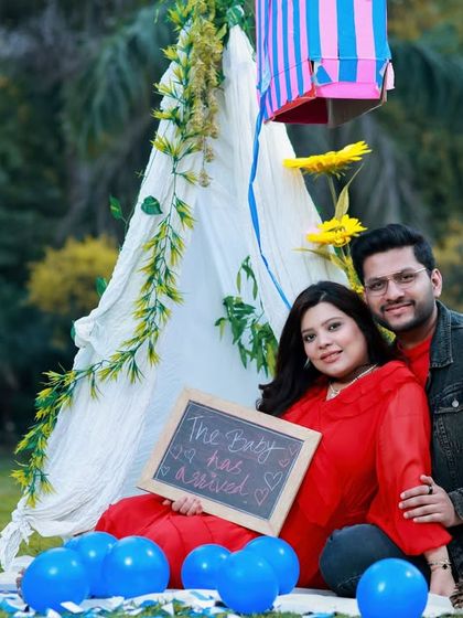 A fun picnic setup in the park for this expecting couple. The chalkboard sign adds a playful touch to their outdoor maternity announcement photo.