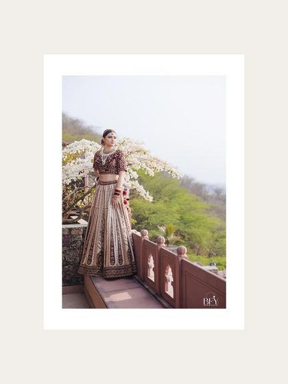 A bride posing against a backdrop of white flowers, her portrait framed in white.