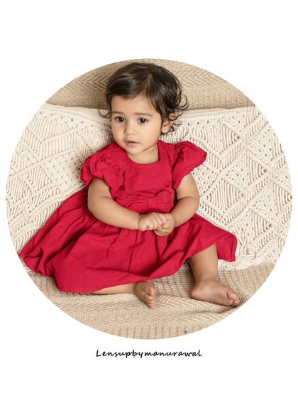 This toddler, dressed in a vibrant red dress, looks absolutely captivating. Milestone sessions are a great way to get beautiful, frame-worthy portraits of your child as they grow.