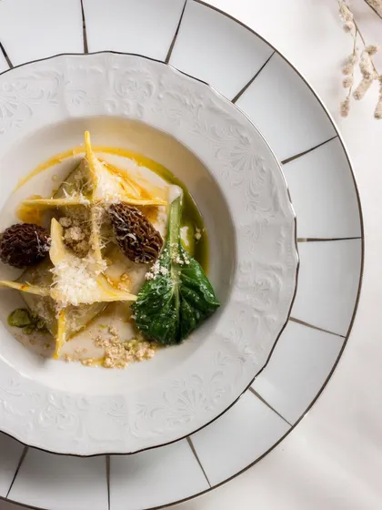 Handcrafted Butternut Squash Manti drizzled with a parmesan yakhni and topped with morels, an elegant and impressive dish from our Holiday Feast by Chef Sujan Sarkar.