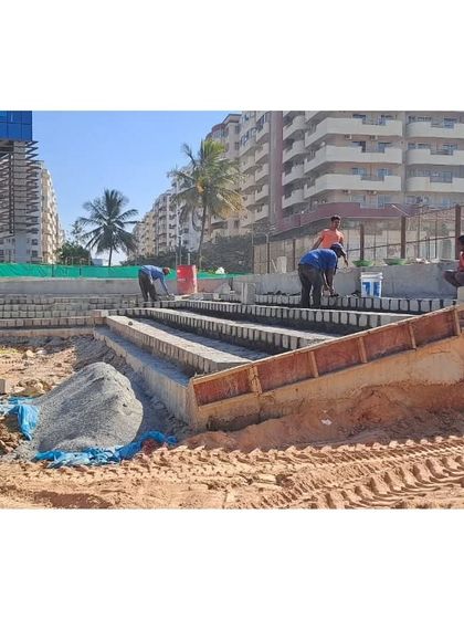 Workers constructing the stepped seating for the amphitheater at Vaishnavi Tech Park. This shows the hands-on nature of bringing our designs to life.