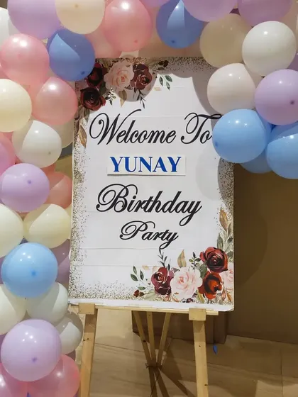 A welcome sign on an easel, framed with pastel balloons, for Yunay's birthday party.