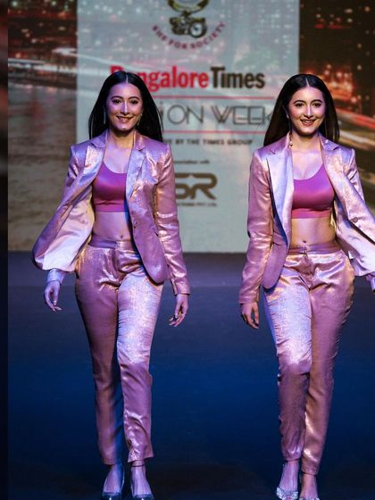 A shot of the Shetty twins walking the ramp in matching metallic suits for a designer at Bangalore Times Fashion Week. Capturing multiple models in a single frame requires precise timing and composition.