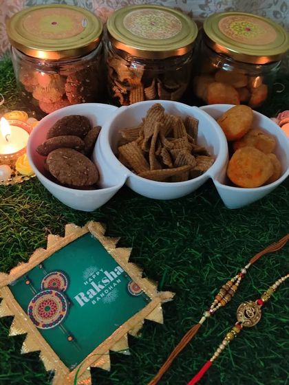 Our Rakhi special snacks displayed in a three-section serving dish, featuring Ragi Cookies, Ragi Chips, and Khasta Kachori.
