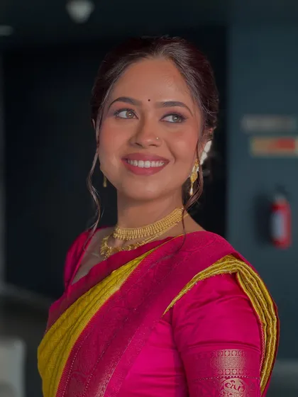 My bride looking radiant and happy, her makeup perfectly complementing her bright, traditional saree.