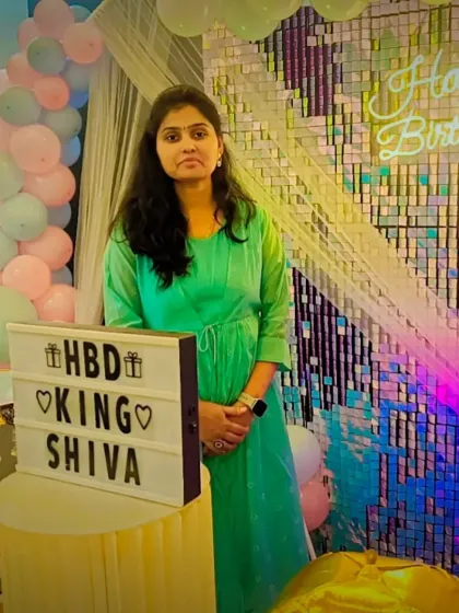 A guest posing next to the custom lightbox and birthday decorations. The sequin wall provides a perfect, sparkling background for all your event photos.
