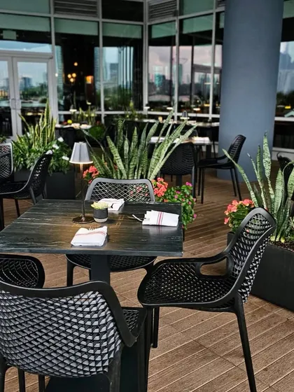 The outdoor patio at LokalJC, surrounded by lush planters. We incorporated greenery to soften the urban setting and create a more intimate, garden-like feel for diners.