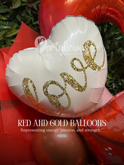 Red and gold balloons represent energy, passion, and strength, making them perfect for a fiery Aries season celebration. This close-up shows a "Love" foil balloon, adding a touch of romance.