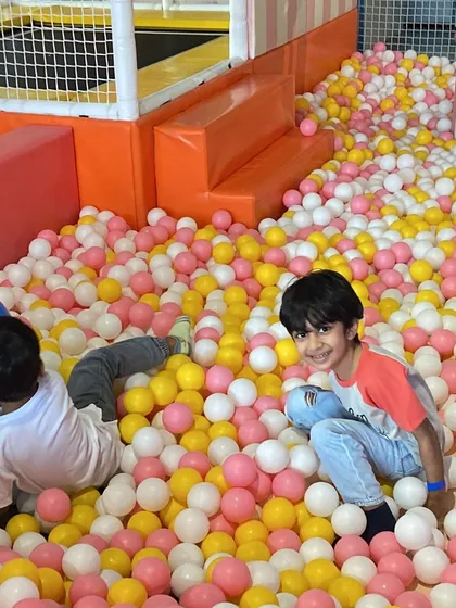 Two friends having a blast in the ball pit during a Paw Patrol themed party.