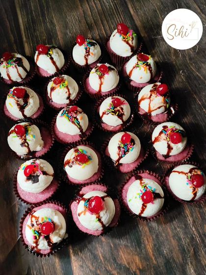 A fun and playful design that looks just like a tiny ice cream sundae. Each cupcake is topped with a scoop of buttercream, chocolate drizzle, rainbow sprinkles, and a cherry on top.