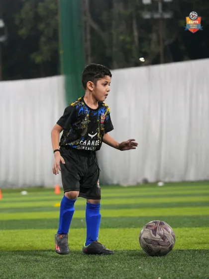 A young player stands ready, focused on the ball and his surroundings. We teach our players to be aware and think ahead during training.