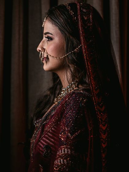A profile shot of the bride in monochrome, focusing on the elegant silhouette of her face and the details of her nath and bridal wear.